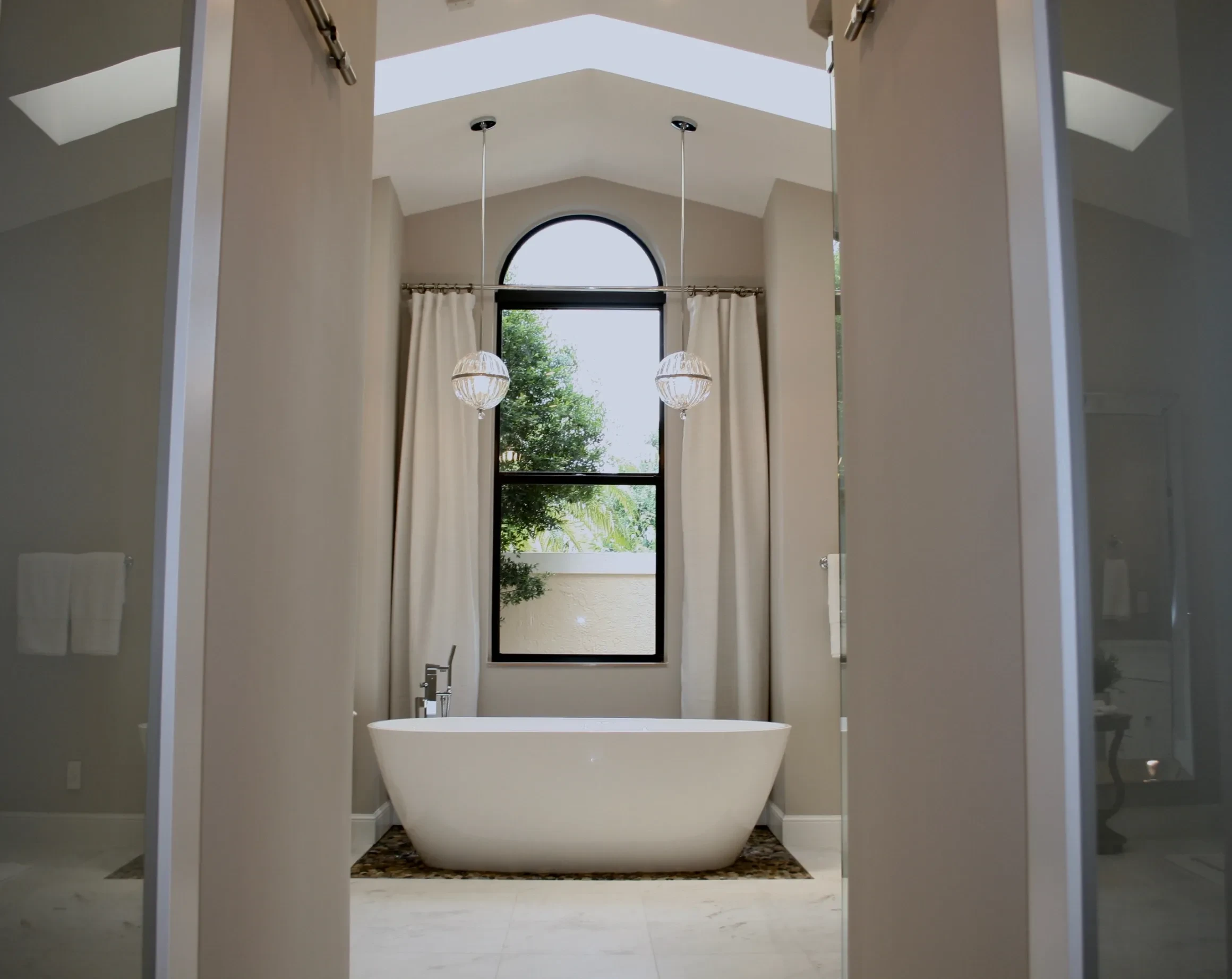 Bathroom with freestanding tub and arched window
