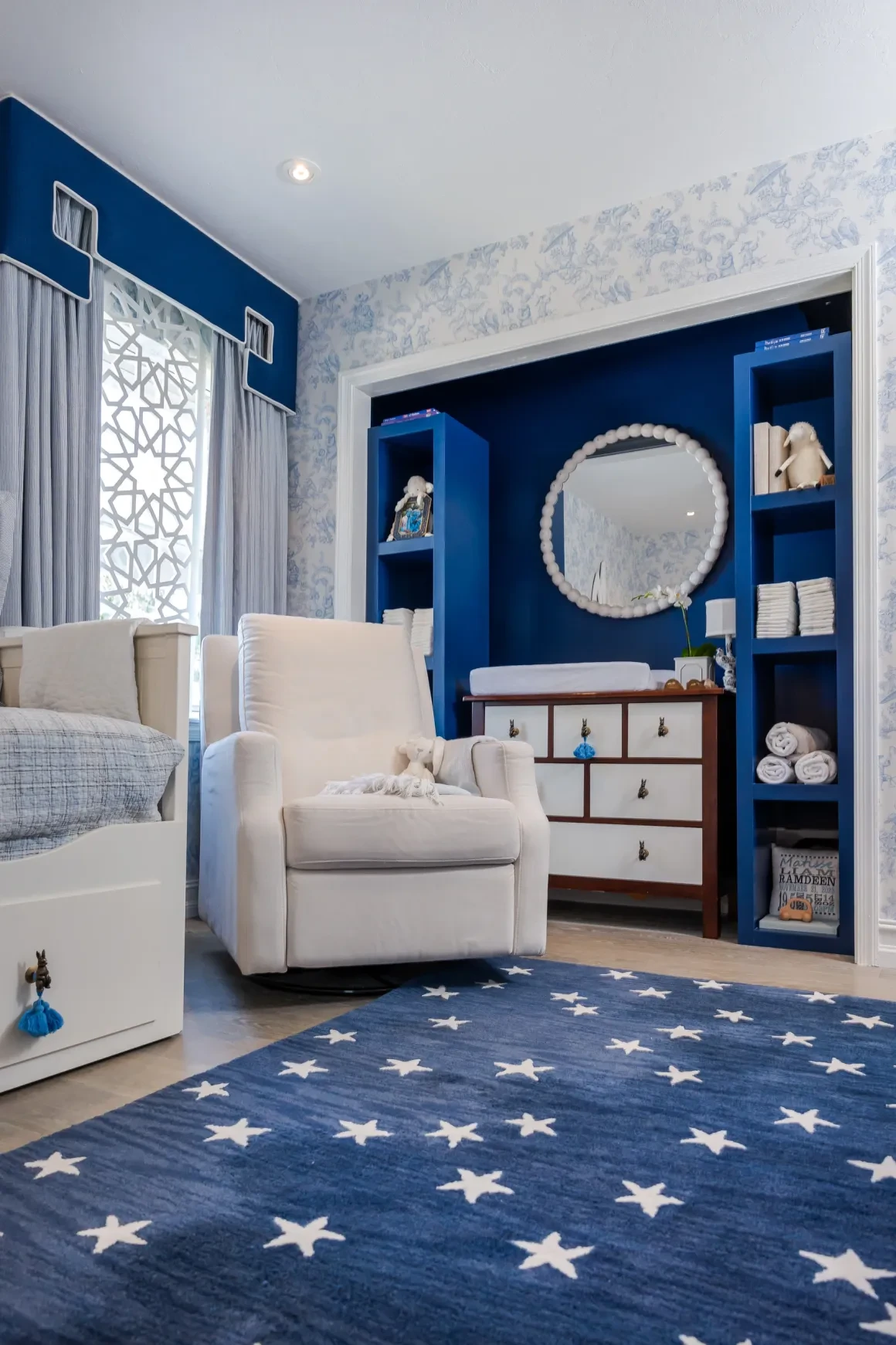 Blue nursery with star-patterned rug and custom shelving